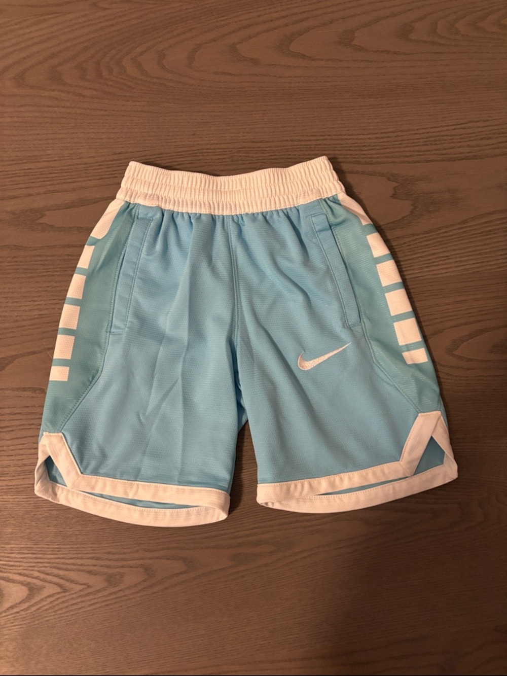 Nike Light Blue and White Kids Athletic Shorts. Note: a bit of pulling on back